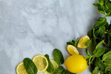 Limon dilimleri, yapraklar ve naneli yaz kompozisyonu. Minimum limonata içeceği konsepti. Üst görünüm