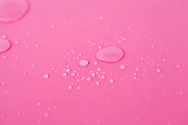 Full frame of the textures formed by the bubbles and drops of water. Drops of water spilled on a light pink surface