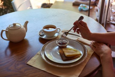 Tahta masada çay içip krep yerken çekilmiş görüntüler.