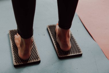 Grup çalışması, çivilerin üzerinde durmak. Sadhu tahtasında keskin tırnakları olan yoga uzmanının yakın çekimi. Sadhu tahta tahtası ve sadhu için çiviler..
