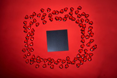 Bir not için boş bir kağıt parçası. Sevgililer günü kalp geçmişi. Bir sürü renkli kalp - sevgililer günü arkaplanı. Kırmızı arka planda şekillendirilmiş güzel dekoratif kalp, Sevgililer Günü konsepti