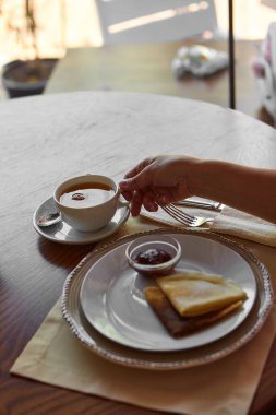 Tahta masada çay içip krep yerken çekilmiş görüntüler.