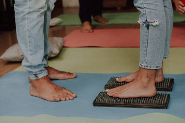 Grup çalışması, çivilerin üzerinde durmak. Sadhu tahtasında keskin tırnakları olan yoga uzmanının yakın çekimi. Sadhu tahta tahtası ve sadhu için çiviler..