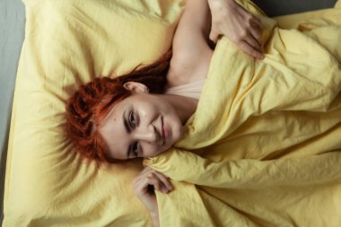 Yatak odasında sabahları yatakta dehşet saçan çok güzel kızıl saçlı bir kız. Kadınsı, nazik bir kız. Sağlık ve Uyku Konsepti. 