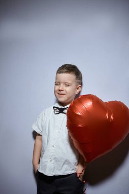 Sevgililer Günü. Mutlu çocuk beyaz arka planda kırmızı topları tutuyor.. 