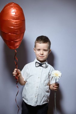 Sevgililer Günü. Mutlu çocuk beyaz arka planda kırmızı topları tutuyor.. 