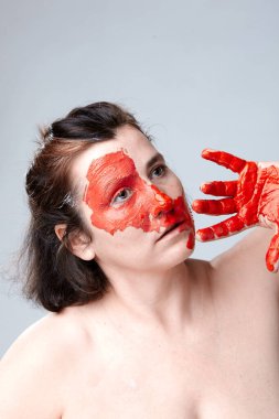 Yüzü boyalı bir kadın portresi. Yaratıcı makyaj ve parlak stil. Yüzü renkli bir kız. Sanat güzelliği. Yüzünde renkli boya olan bir kız.. 