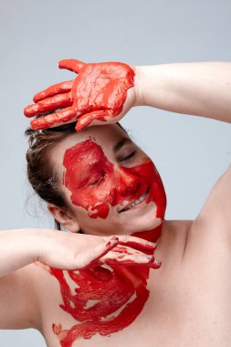 Yüzü boyalı bir kadın portresi. Yaratıcı makyaj ve parlak stil. Yüzü renkli bir kız. Sanat güzelliği. Yüzünde renkli boya olan bir kız.. 