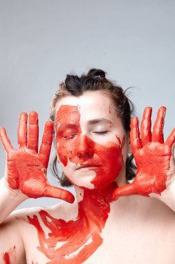 Yüzü boyalı bir kadın portresi. Yaratıcı makyaj ve parlak stil. Yüzü renkli bir kız. Sanat güzelliği. Yüzünde renkli boya olan bir kız.. 