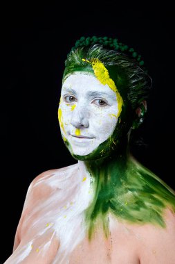 Yüzü boyalı bir kadın portresi. Yaratıcı makyaj ve parlak stil. Yüzü renkli bir kız. Sanat güzelliği. Yüzünde renkli boya olan bir kız.. 