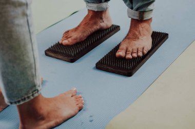 Grup çalışması, çivilerin üzerinde durmak. Sadhu tahtasında keskin tırnakları olan yoga uzmanının yakın çekimi. Sadhu tahta tahtası ve sadhu için çiviler..
