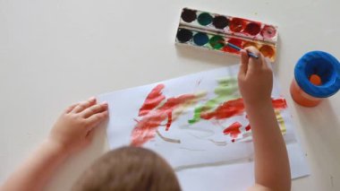 Çocuk odasında resim çiziyor.