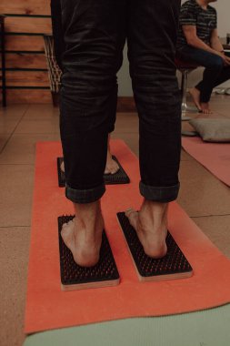 Grup çalışması, çivilerin üzerinde durmak. Sadhu tahtasında keskin tırnakları olan yoga uzmanının yakın çekimi. Sadhu tahta tahtası ve sadhu için çiviler..