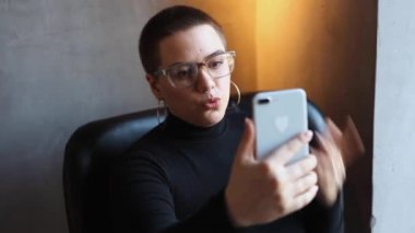 Gözlüklü bir kadın video bağlantısıyla konuşuyor