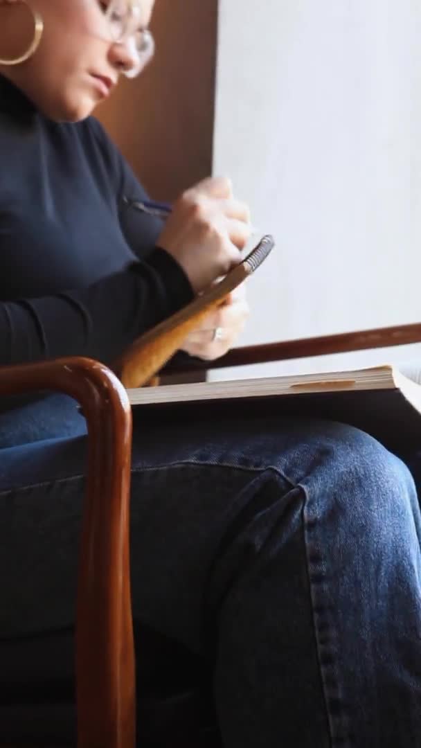 Egy nő ül egy kávézóban és egy tabletnél dolgozik.. — Stock videók