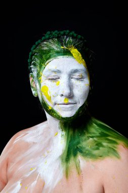 Yüzü boyalı bir kadın portresi. Yaratıcı makyaj ve parlak stil. Yüzü renkli bir kız. Sanat güzelliği. Yüzünde renkli boya olan bir kız.. 