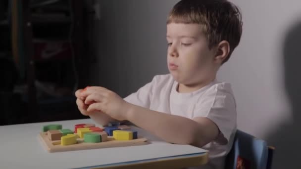 Um menino jogando com um jogo de lógica em casa — Vídeo de Stock