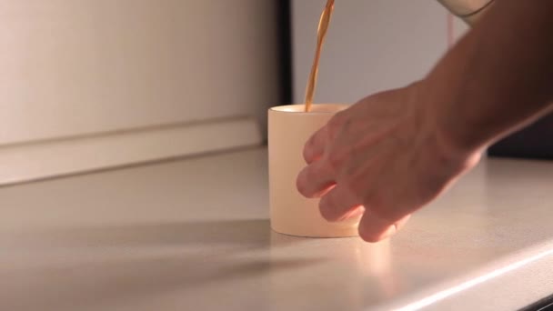 コーヒーメーカーからカップにコーヒーを注ぐプロセス 新鮮なコーヒーが流れる 午前中は焙煎黒コーヒーを飲む 高画質映像 — ストック動画