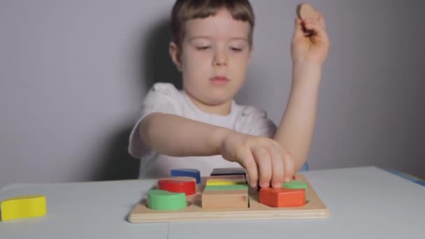 소년은 화이트 테이블에 Wooden Sorter 집에서 놀이를 티셔츠를 아이가 교육용 — 비디오