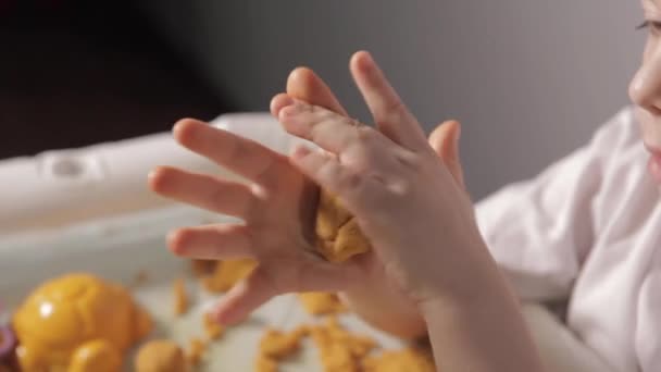 Een Jongen Zit Aan Een Witte Tafel Speelt Thuis Met — Stockvideo