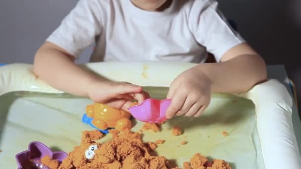 Pojke Sitter Vid Vita Bordet Och Leker Med Kinetisk Sand — Stockvideo