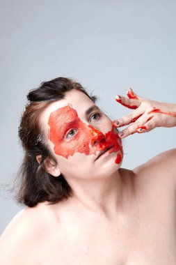 Yüzü boyalı bir kadın portresi. Yaratıcı makyaj ve parlak stil. Yüzü renkli bir kız. Sanat güzelliği. Yüzünde renkli boya olan bir kız.. 