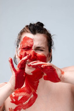 Yüzü boyalı bir kadın portresi. Yaratıcı makyaj ve parlak stil. Yüzü renkli bir kız. Sanat güzelliği. Yüzünde renkli boya olan bir kız.. 