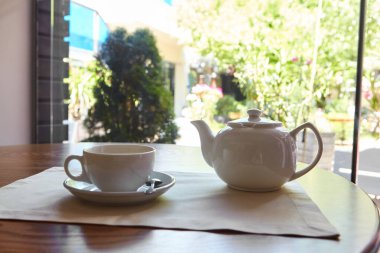 Masa çay için hazır. Terasa bakan masaya bir çaydanlık ve bir çay fincanı konur.