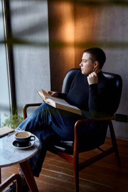 Genç bir kız bir kafede oturmuş kitap okuyor. Eğitim ve uzak çalışma kavramı 