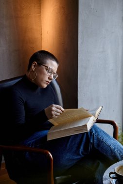 Genç bir kız bir kafede oturmuş kitap okuyor. Eğitim ve uzak çalışma kavramı 