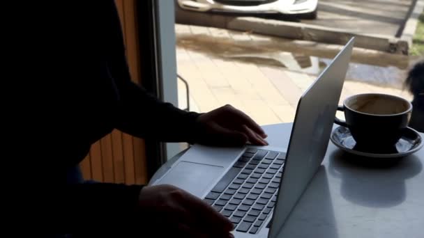 Bir kadın kafede oturur ve dizüstü bilgisayarda çalışır.. — Stok video