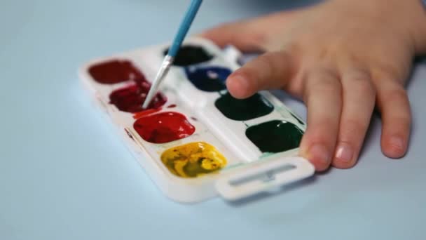 Enfant peignant un tableau avec des couleurs de l'eau Gros plan — Video