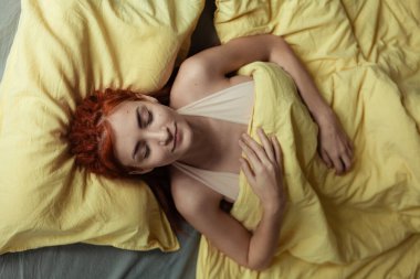 Yatak odasında sabahları yatakta dehşet saçan çok güzel kızıl saçlı bir kız. Kadınsı, nazik bir kız. Sağlık ve Uyku Konsepti. 