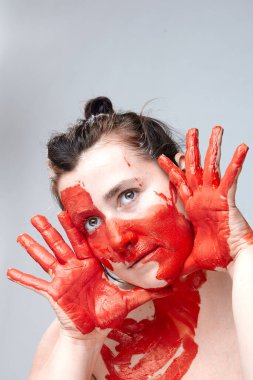 Yüzü boyalı bir kadın portresi. Yaratıcı makyaj ve parlak stil. Yüzü renkli bir kız. Sanat güzelliği. Yüzünde renkli boya olan bir kız.. 