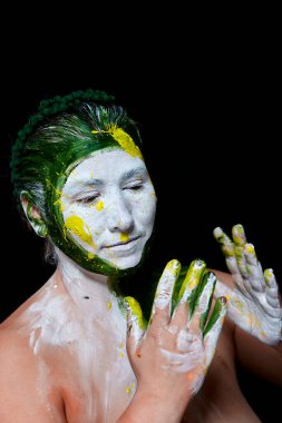 Yüzü boyalı bir kadın portresi. Yaratıcı makyaj ve parlak stil. Yüzü renkli bir kız. Sanat güzelliği. Yüzünde renkli boya olan bir kız.. 