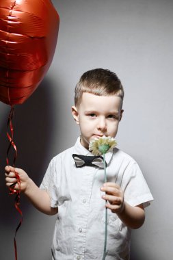 Sevgililer Günü. Mutlu çocuk beyaz arka planda kırmızı topları tutuyor.. 