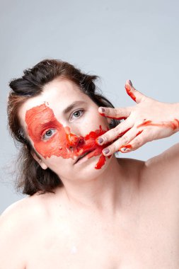 Yüzü boyalı bir kadın portresi. Yaratıcı makyaj ve parlak stil. Yüzü renkli bir kız. Sanat güzelliği. Yüzünde renkli boya olan bir kız.. 