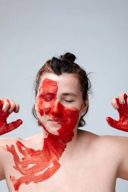 Yüzü boyalı bir kadın portresi. Yaratıcı makyaj ve parlak stil. Yüzü renkli bir kız. Sanat güzelliği. Yüzünde renkli boya olan bir kız.. 