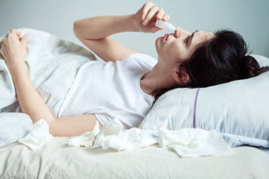 Genç bir kadın yatakta üşür. Battaniyenin altında ısınmaya çalışıyor. Hasta kız burnuna bir damla soğuk gömüyor. Soğuk hava kavramı. Kadın yatakta yatıyor ve ateşi var. 