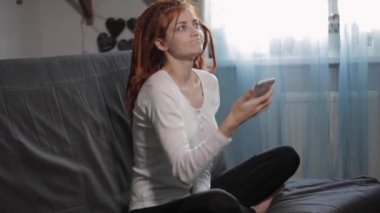 Evinde akıllı telefon ve tripodu kullanarak video kaydeden veya canlı yayın yapan bir kadın blogcu. Canlı yayın yapan canlı yayın sunucusu, dijital sosyal medya kaydediyor.