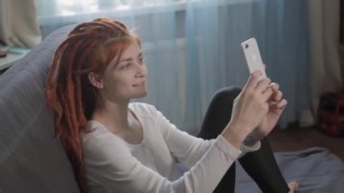 Evinde akıllı telefon ve tripodu kullanarak video kaydeden veya canlı yayın yapan bir kadın blogcu. Canlı yayın yapan canlı yayın sunucusu, dijital sosyal medya kaydediyor.