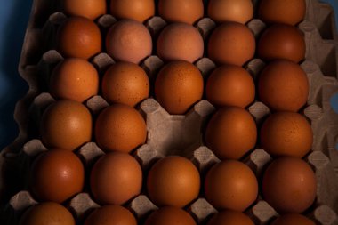 Kahverengi tavuk yumurtalarından oluşan bir kaset, doğal bir alt katmanda, üst katmanda. Yemek arkaplanı. Kasetteki yumurtalar.