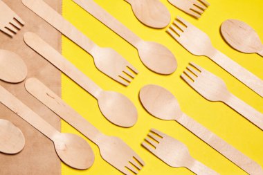 Bambu ahşap ve kağıttan yapılmış çevre dostu tek kullanımlık sofra takımı. Doğal malzemelerden, tahta kaşıktan, çataldan, çevre dostu tek kullanımlık eşyalar. Mesaj için yer. Tek kullanımlık ahşap çay kaşıklarının yerleşimi 