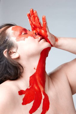 Yüzü boyalı bir kadın portresi. Yaratıcı makyaj ve parlak stil. Yüzü renkli bir kız. Sanat güzelliği. Yüzünde renkli boya olan bir kız.. 