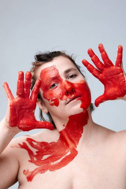 Yüzü boyalı bir kadın portresi. Yaratıcı makyaj ve parlak stil. Yüzü renkli bir kız. Sanat güzelliği. Yüzünde renkli boya olan bir kız.. 