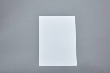 Beyaz kağıt kaplamalı lavanta çiçekleri gri arka planda. Beyaz kağıt boş, gri masada kurumuş çiçekler. Davetiye kartı mockup.Düz konum, üst görünüm, kopyalama alanı, maket