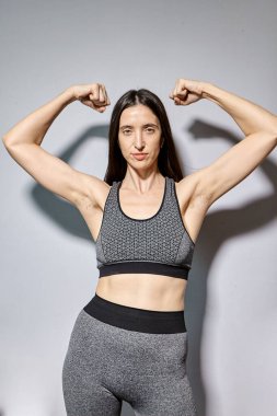 Bir kadın koltuk altlarındaki kılları göstermek için elini kaldırdı. Tıraşsız koltuk altları olan doğal bir kız. Feminist konsept. Koltuk altı kıllı bir kadın. Vücut pozitif. Feminist hareket. Dağıtım