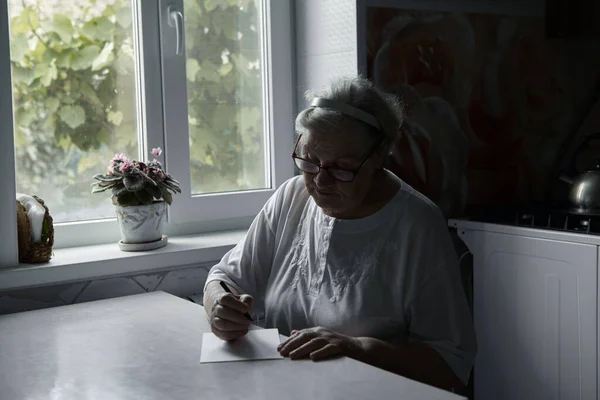 Eine Ältere Frau Schreibt Hause Auf Einen Zettel Hobbys Von — Stockfoto