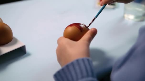 Niño Pequeño Pinta Huevo Pascua Mesa Sobre Fondo Azul Little — Vídeos de Stock