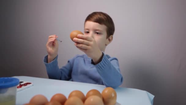 Małe Dziecko Maluje Wielkanocne Jajko Przy Stole Niebieskim Tle Mały — Wideo stockowe